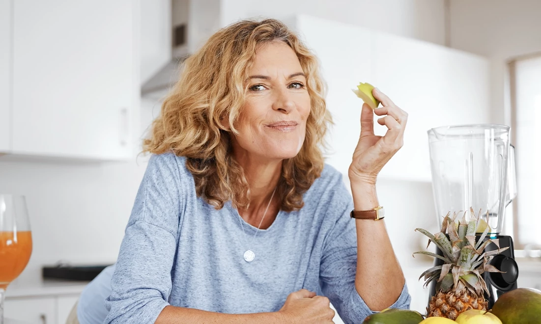 Frau isst Obst und lächelt