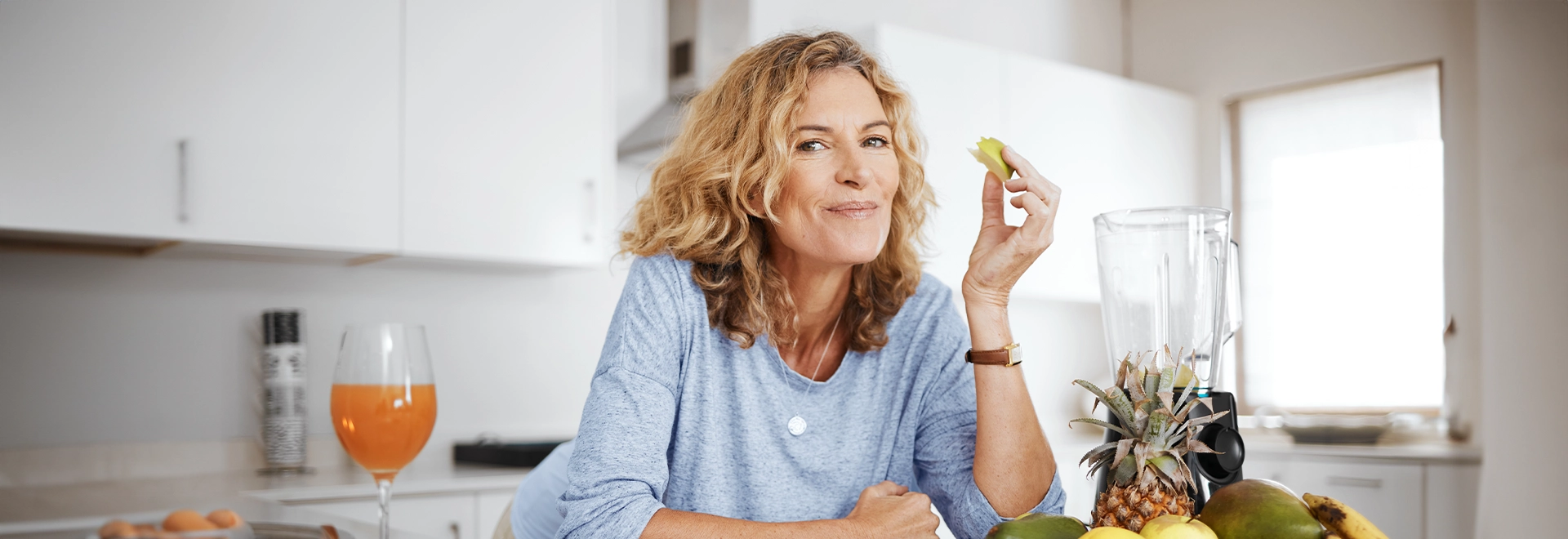 Frau isst Obst und lächelt