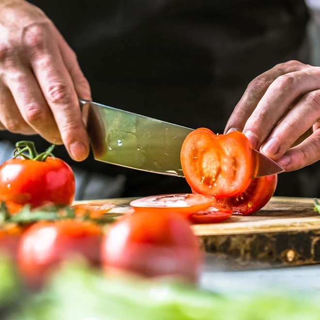 Nahaufnahme eines Mannes der Tomaten zubereitet